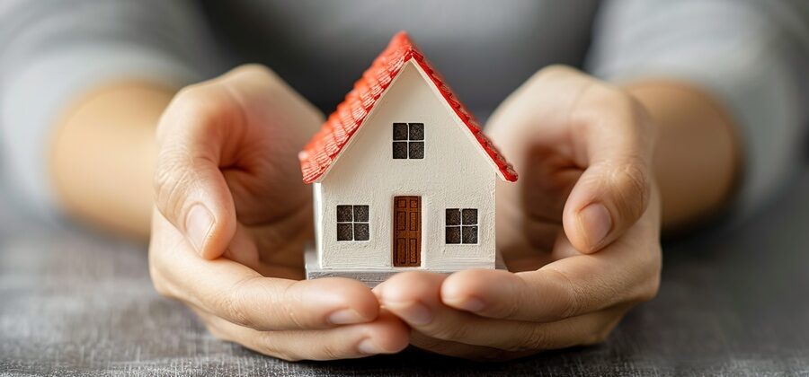 real estate closings concept - hands holding miniature house